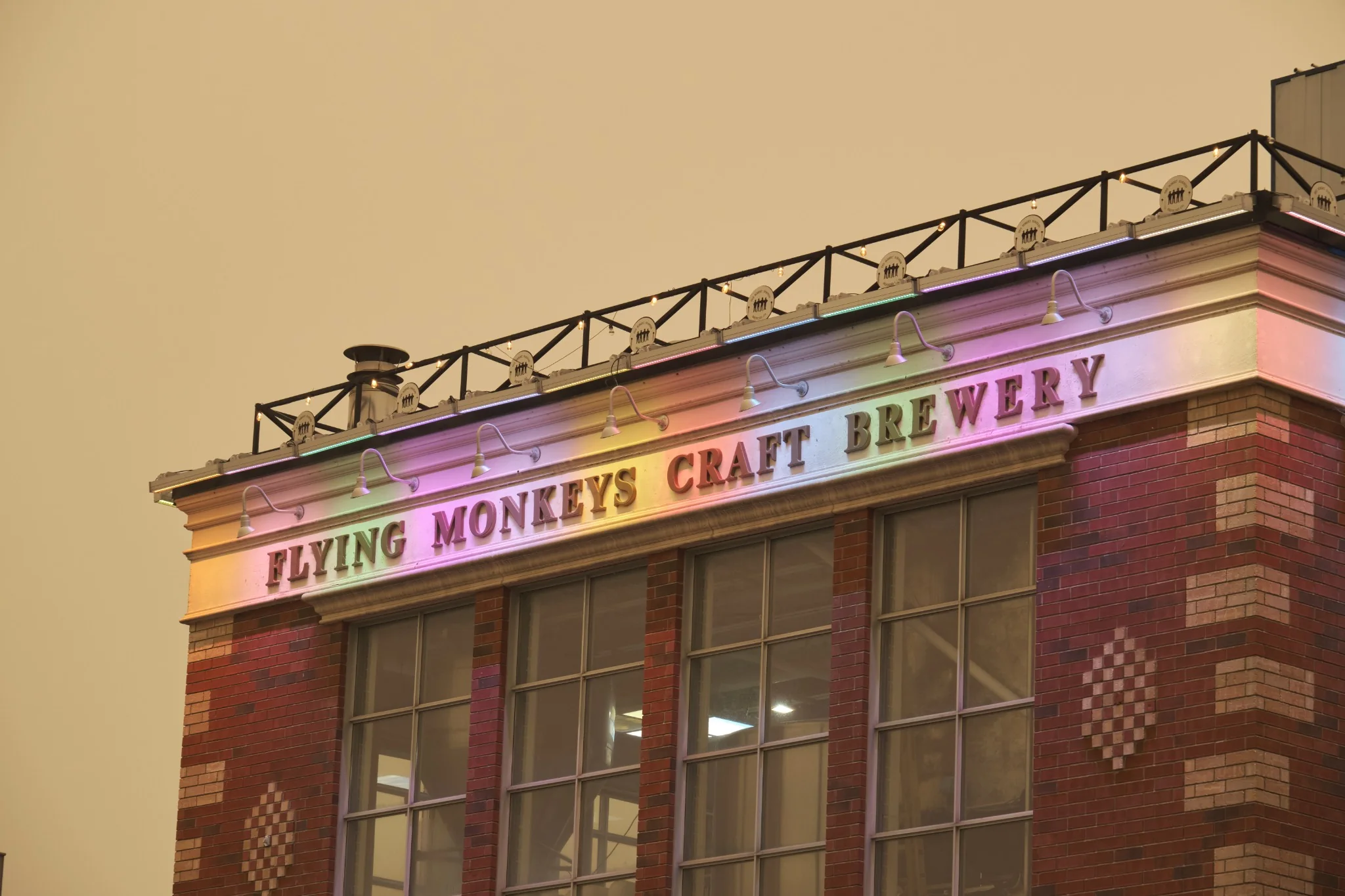Brick brewery facade illuminated by coloured signage