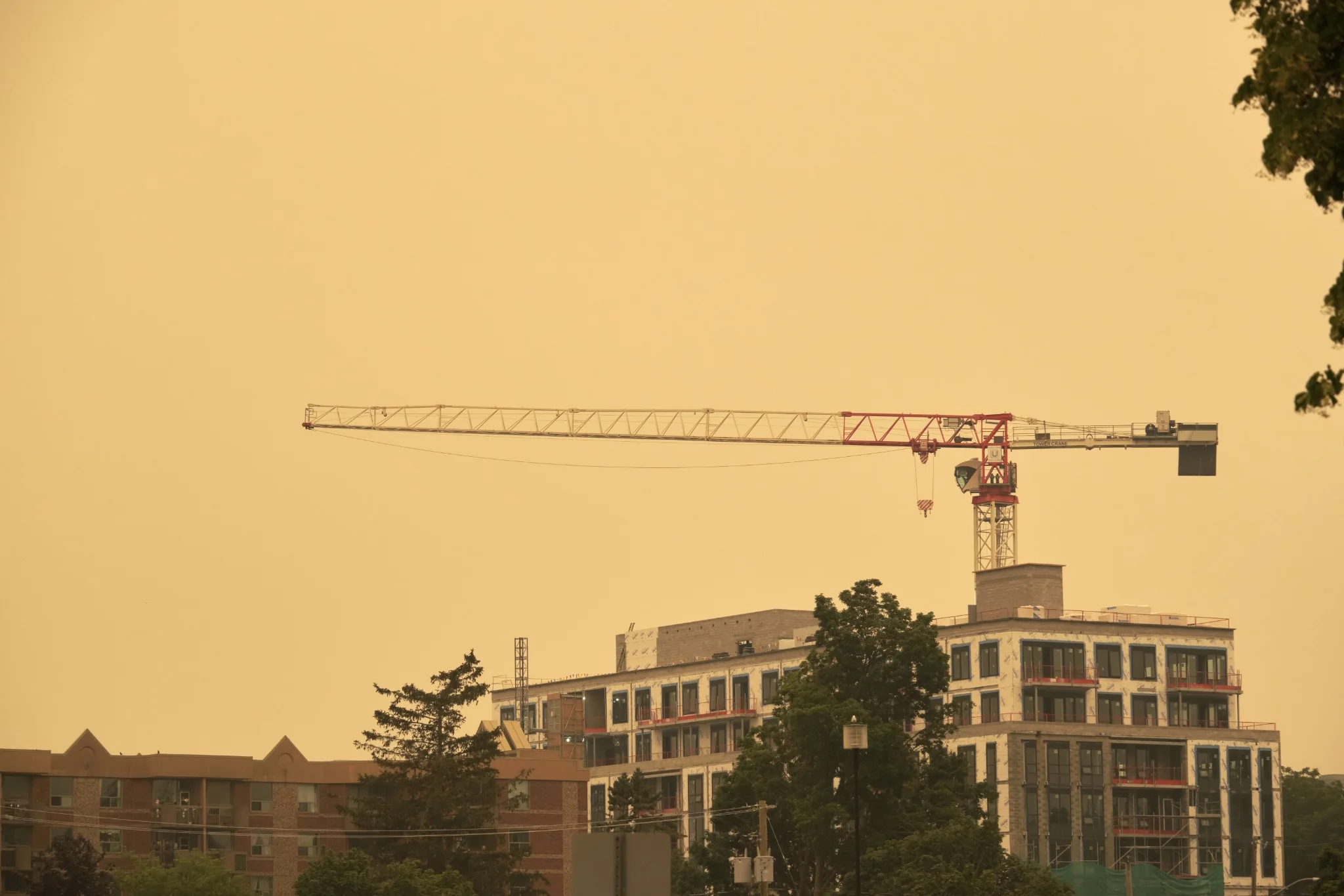 Tower crane above a building under construction in a smoke-filled cityscape