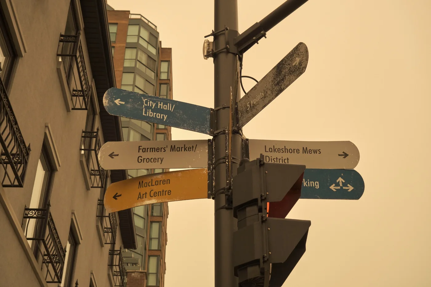 Weathered urban wayfinding signs at an intersection